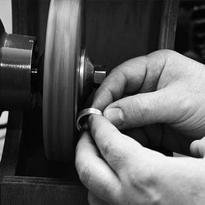 Jewellery maker at work polishing ring