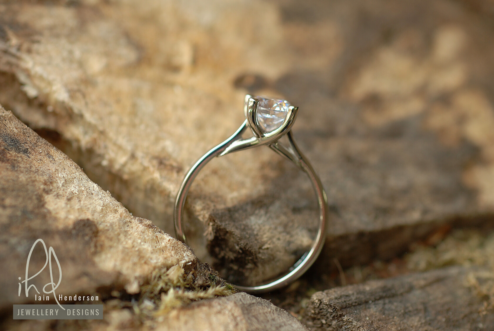 Solitaire engagement ring with a classic four claw style setting, and a cross over feature