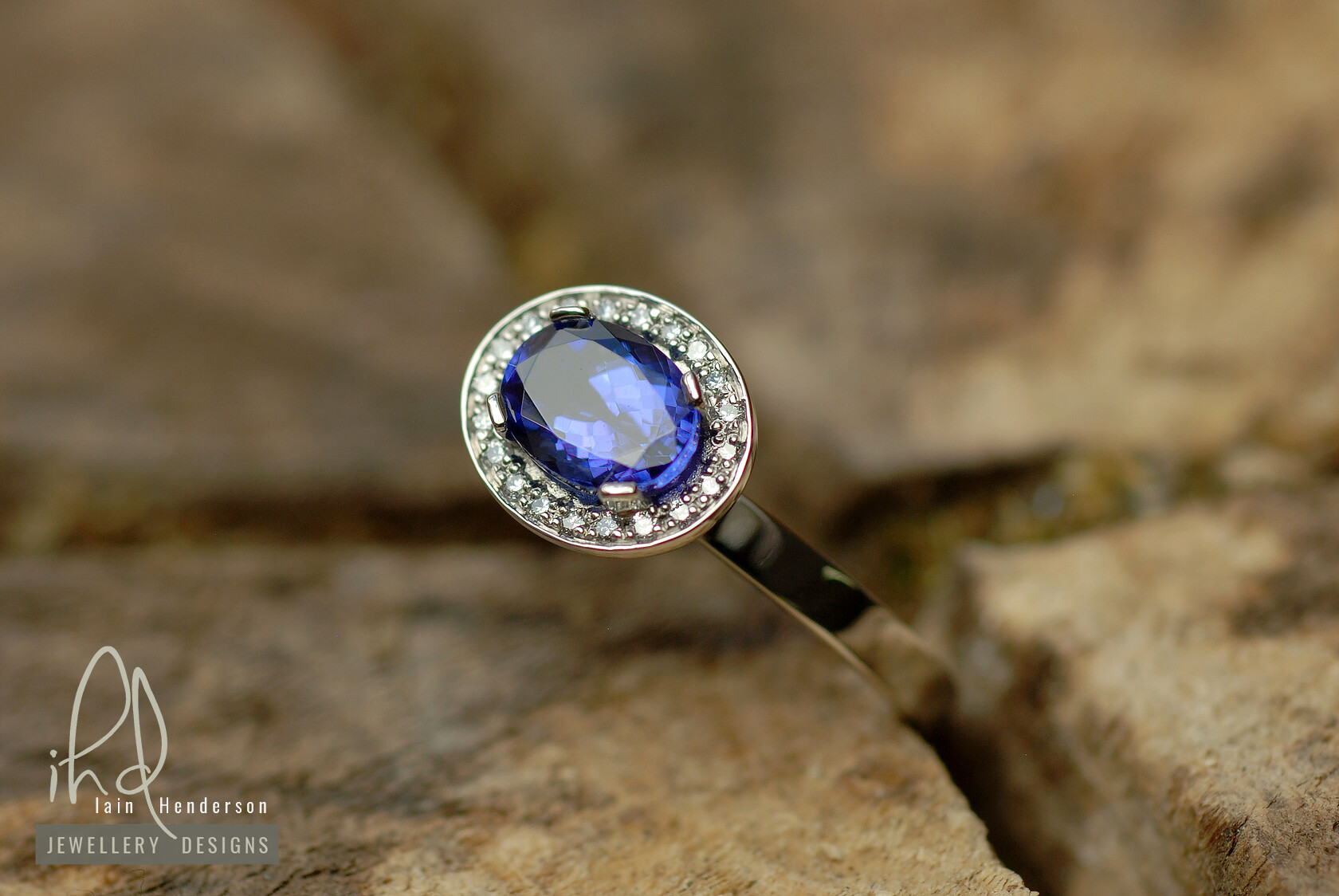 Halo style engagement ring with an oval sapphire and small white diamonds