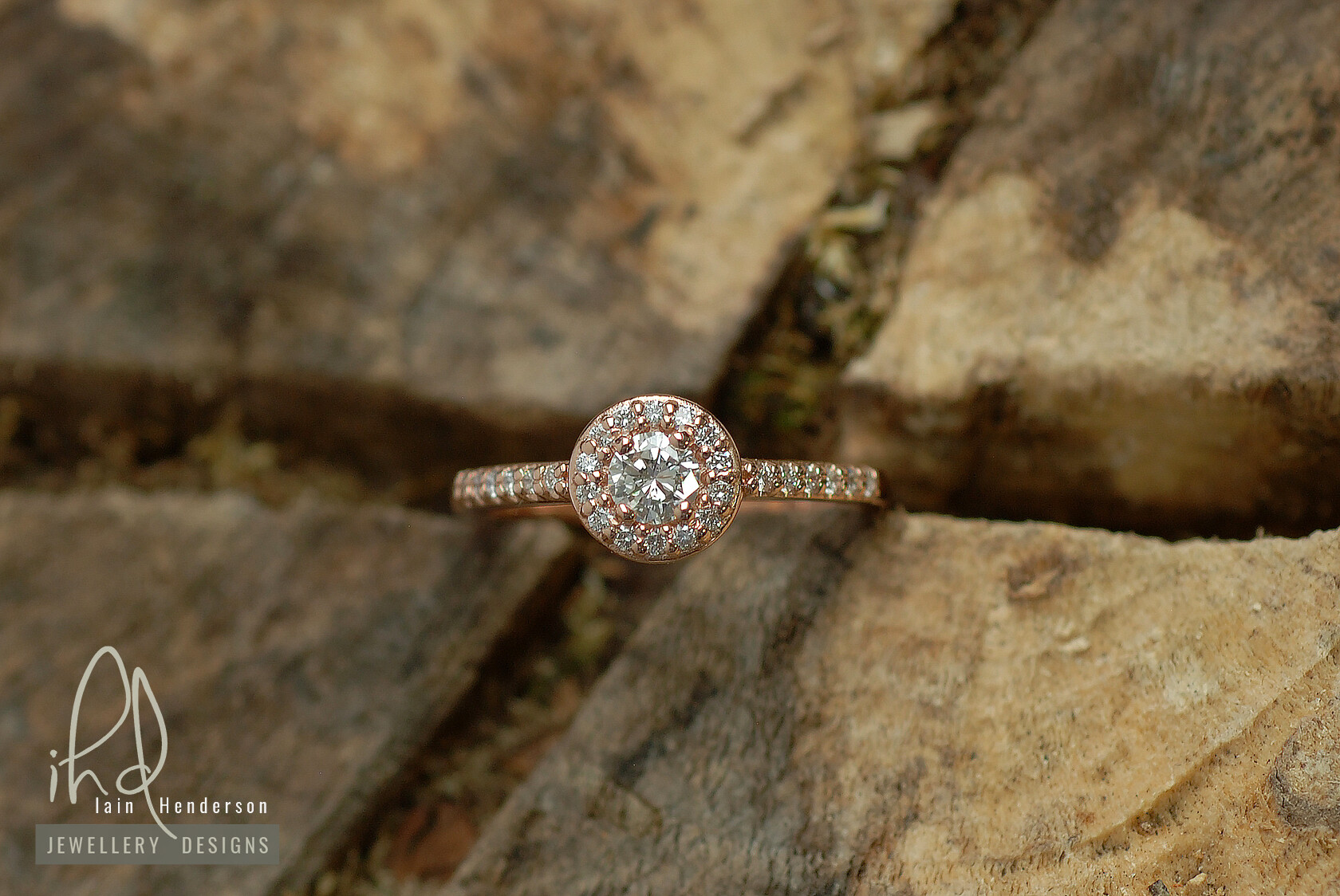 Rose gold halo engagement ring with diamonds on the shoulders