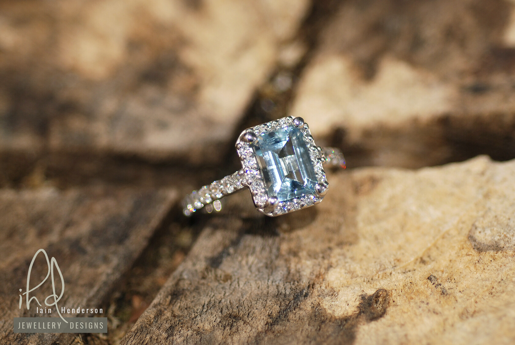 Aqua marine halo style engagement ring with diamonds on the shoulders